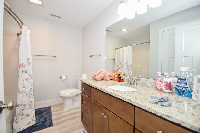 full bathroom with vanity, toilet, visible vents, baseboards, and wood finished floors