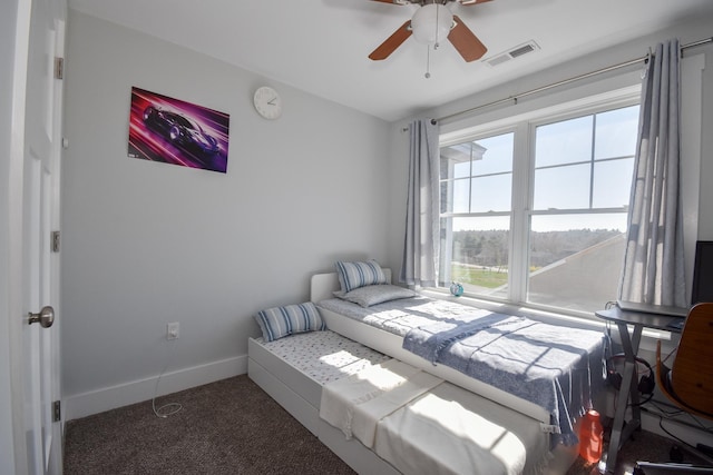 carpeted bedroom with visible vents, a ceiling fan, and baseboards
