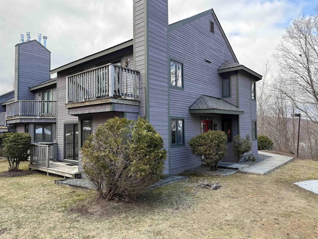 rear view of property with a chimney and a balcony