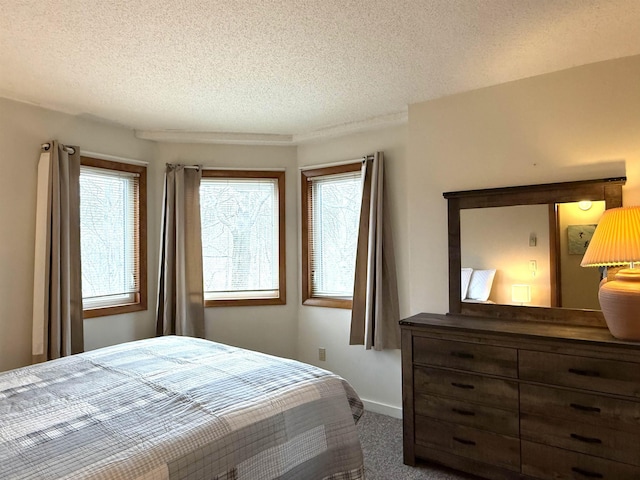 carpeted bedroom with a textured ceiling and baseboards