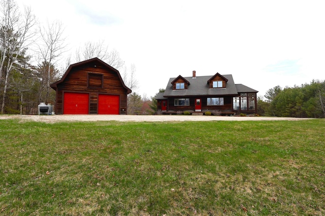 log-style house featuring an outdoor structure, a barn, a chimney, a detached garage, and a front yard