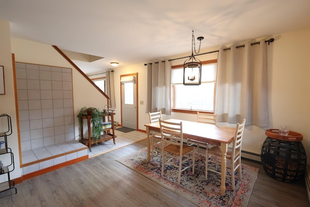dining space featuring baseboard heating and wood finished floors