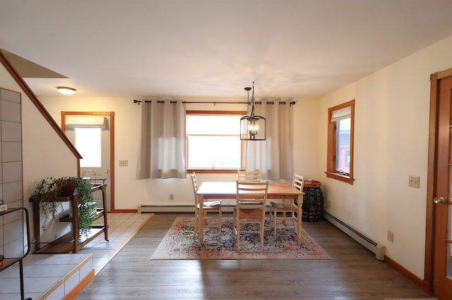 dining room featuring plenty of natural light, wood finished floors, and a baseboard radiator