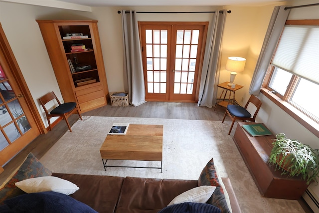 interior space featuring wood finished floors, french doors, and a baseboard radiator