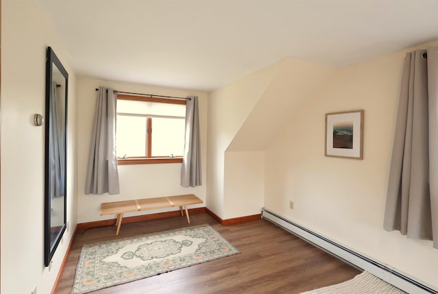 additional living space featuring baseboards, baseboard heating, wood finished floors, and a baseboard radiator