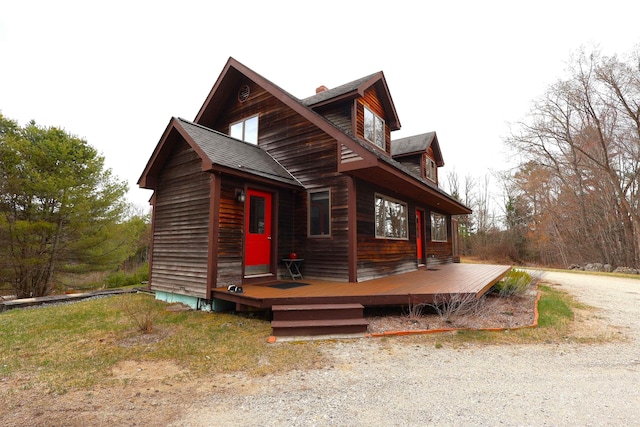 view of front of home with roof with shingles and a deck
