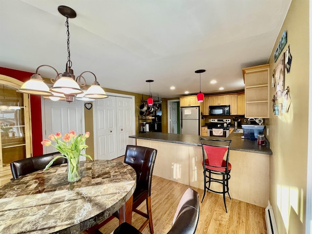 dining area with baseboard heating, light wood-type flooring, and recessed lighting