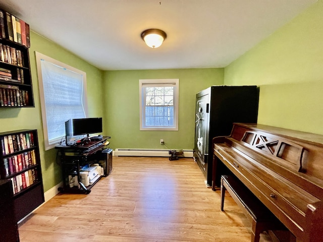 office area featuring light wood-style flooring, a baseboard heating unit, and baseboards