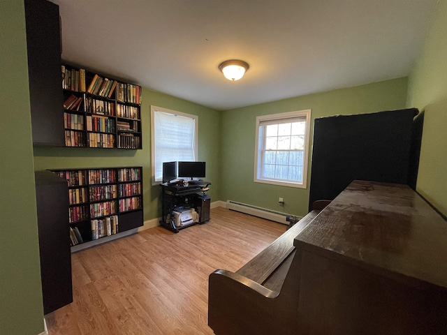 bedroom featuring baseboards, wood finished floors, and a baseboard radiator