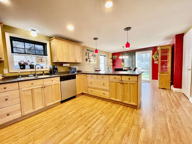 kitchen featuring a sink, dark countertops, light brown cabinetry, dishwasher, and a peninsula