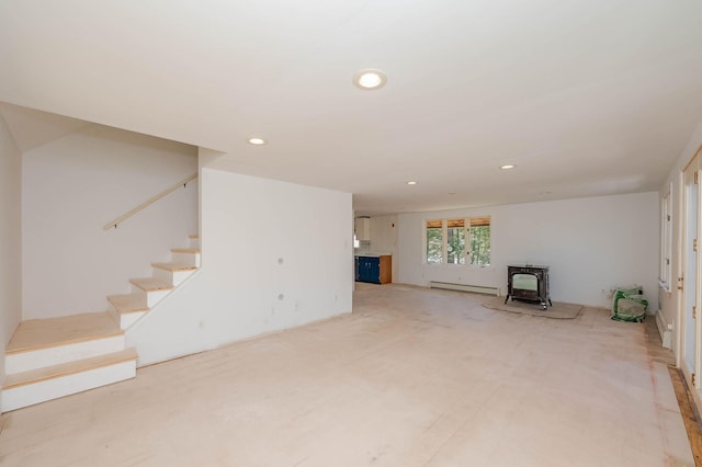 unfurnished living room featuring stairway, recessed lighting, a wood stove, and a baseboard heating unit