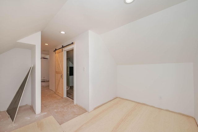 bonus room with a barn door, recessed lighting, and vaulted ceiling