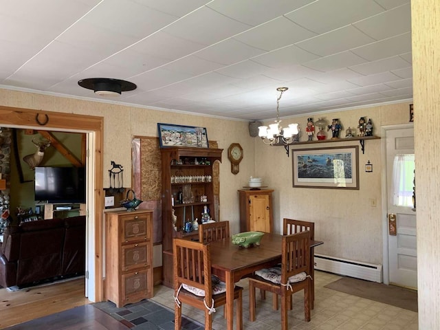 dining space featuring ornamental molding, baseboard heating, and a chandelier