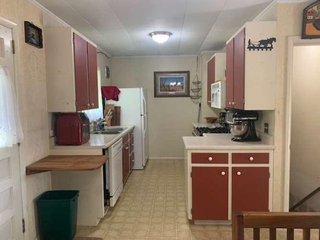 kitchen featuring light floors, white appliances, light countertops, a sink, and baseboards