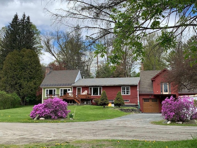 single story home featuring a garage, a chimney, a front lawn, and driveway
