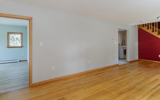 152 E St, Charlestown, NH 03603 - empty room with washer / dryer, a baseboard radiator, stairway, and wood finished floors