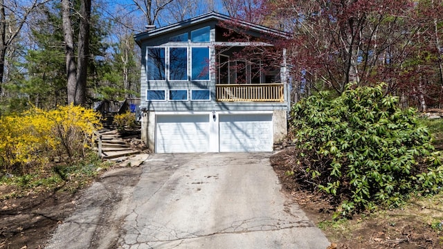 view of front of house with a balcony, concrete driveway, and an attached garage