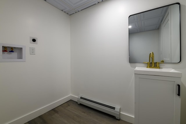 laundry area featuring hookup for a washing machine, wood finished floors, electric dryer hookup, a baseboard heating unit, and baseboards
