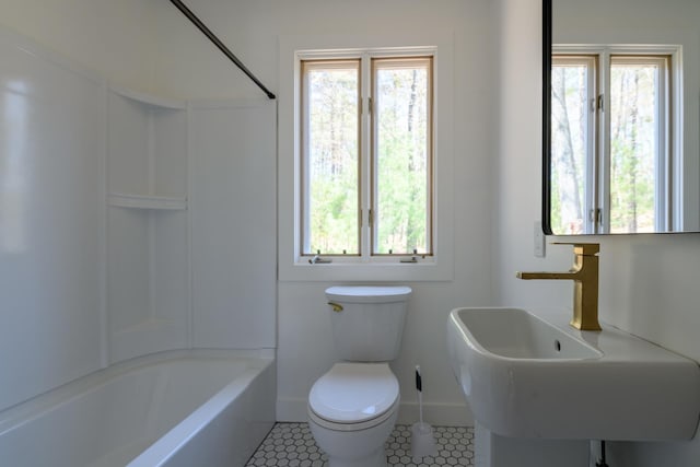 full bathroom featuring a sink, baseboards, toilet, shower / washtub combination, and tile patterned flooring