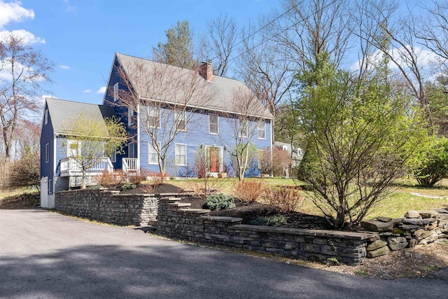 colonial-style house with a porch and a chimney