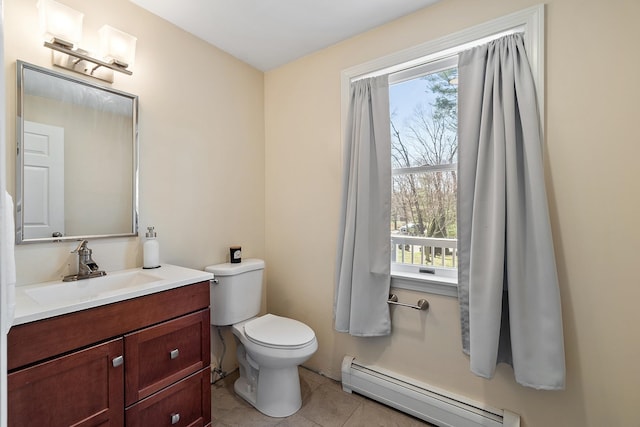 bathroom featuring tile patterned floors, a healthy amount of sunlight, toilet, and a baseboard heating unit