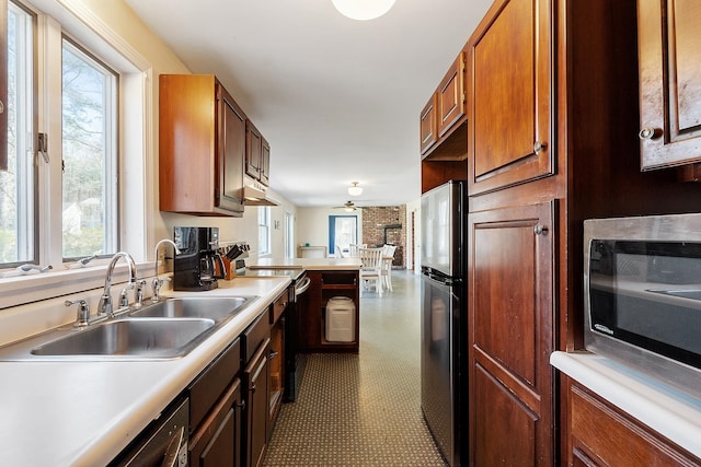 kitchen featuring appliances with stainless steel finishes, tile patterned floors, light countertops, and a sink