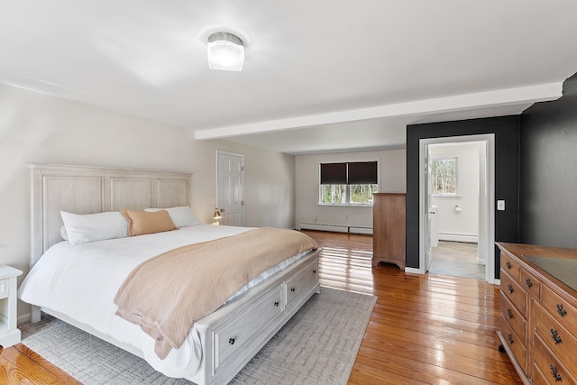 bedroom featuring light wood-style floors, baseboard heating, and baseboards