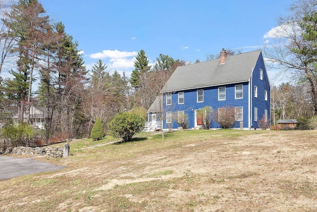 rear view of house with a yard and a chimney