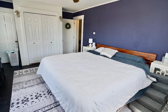 bedroom featuring a closet, ornamental molding, ceiling fan, and wood finished floors