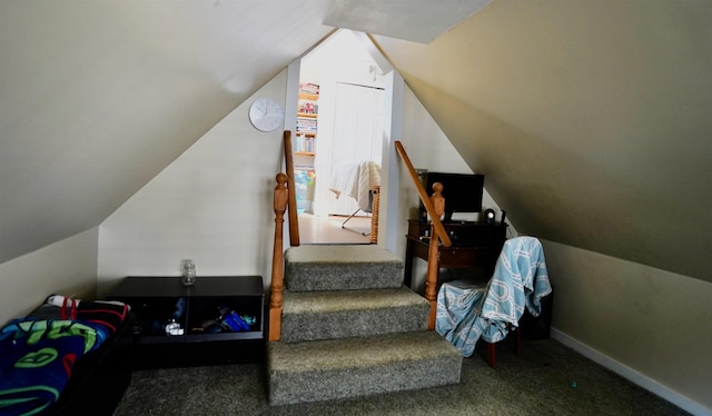 staircase featuring baseboards, carpet flooring, and lofted ceiling