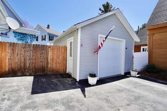 exterior space featuring fence, an outbuilding, and a detached garage