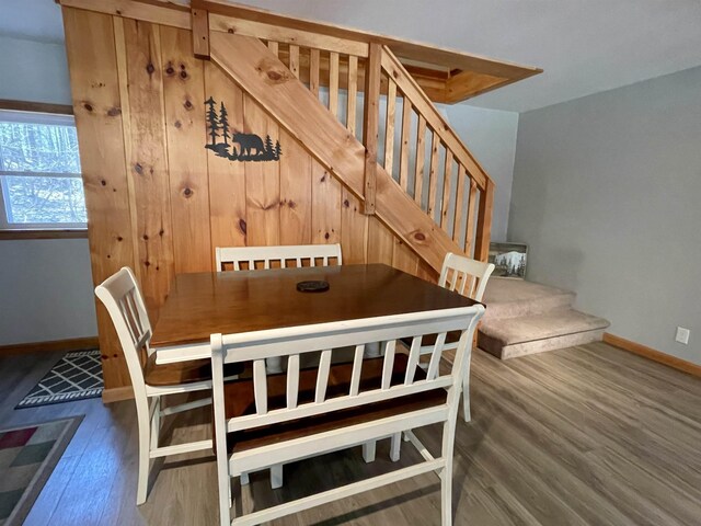 dining area featuring stairway, baseboards, and wood finished floors
