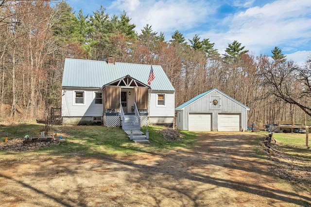 134 Peverly Rd, Northfield, NH 03276 - view of front facade featuring an outdoor structure, a garage, a chimney, dirt driveway, and metal roof
