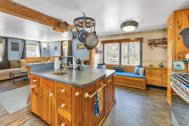 134 Peverly Rd, Northfield, NH 03276 - kitchen with dark countertops, open floor plan, stainless steel range with gas cooktop, brown cabinets, and a sink