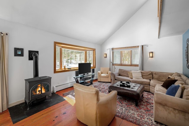 living area with wood-type flooring, plenty of natural light, and a wood stove