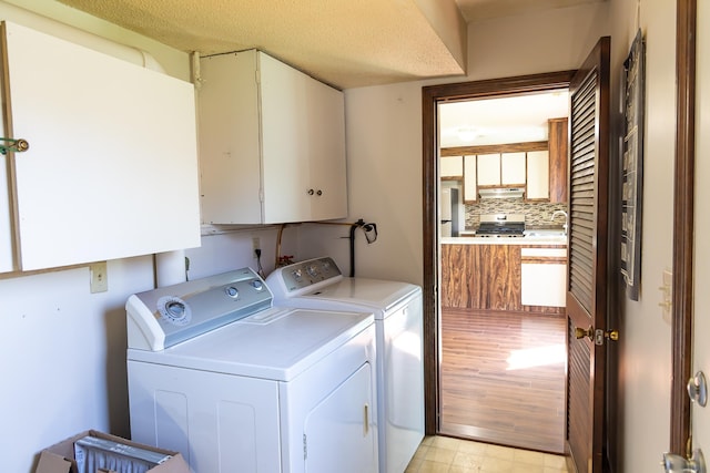 laundry room with cabinet space, independent washer and dryer, and a sink