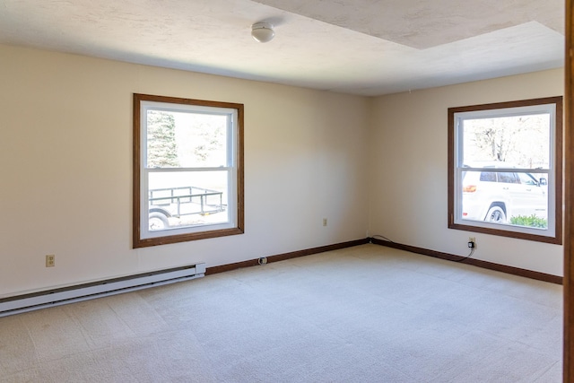 spare room featuring baseboards, light colored carpet, plenty of natural light, and baseboard heating