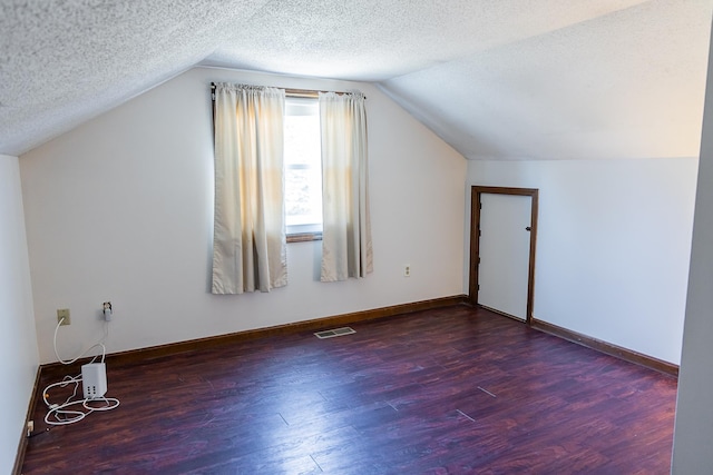bonus room featuring lofted ceiling, wood finished floors, and visible vents