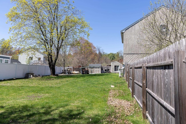 view of yard featuring an outdoor structure, a fenced backyard, and a storage shed