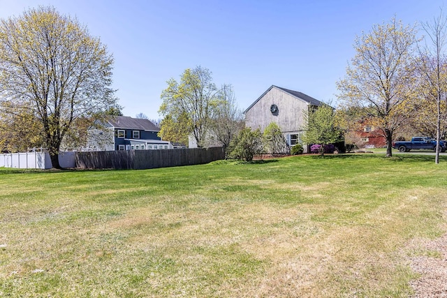 view of yard featuring fence and a barn