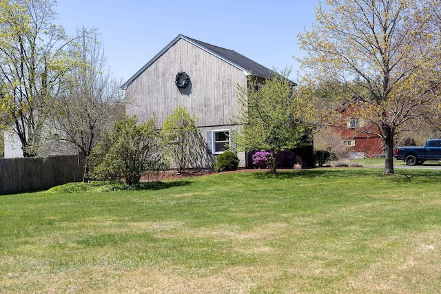 exterior space with fence, a barn, and a yard