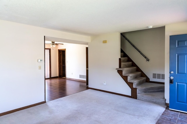 interior space with stairway, baseboards, ceiling fan, and visible vents