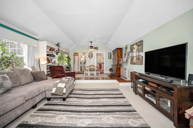 carpeted living area featuring baseboards, ceiling fan, and lofted ceiling