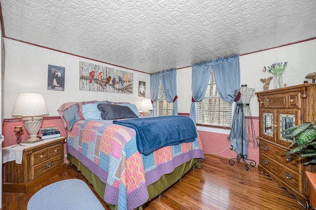 bedroom featuring an ornate ceiling and wood finished floors