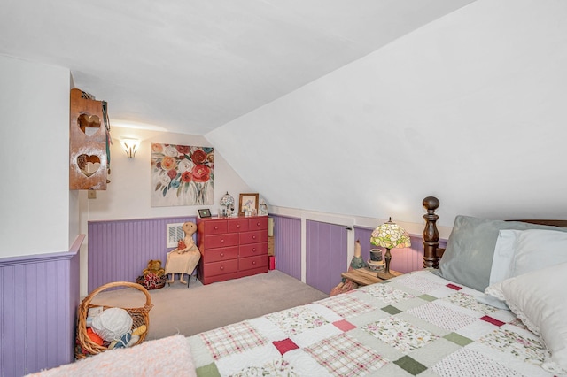 bedroom with carpet flooring, vaulted ceiling, and wainscoting