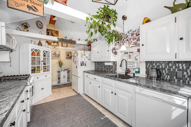 kitchen with a sink, decorative backsplash, white appliances, and white cabinetry