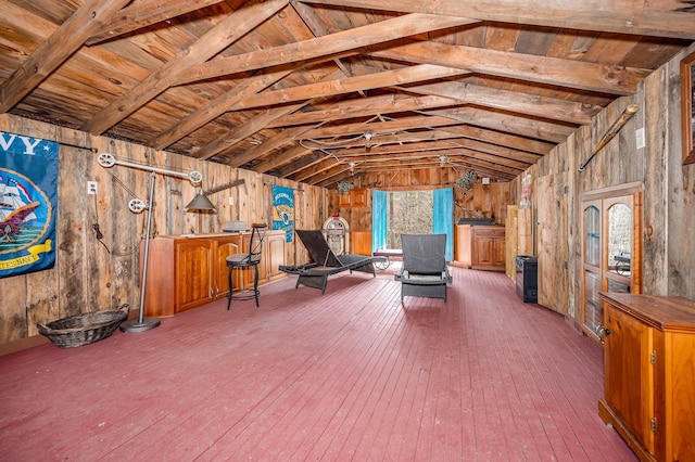 living area featuring wood-type flooring, wood walls, and lofted ceiling