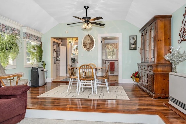 dining area with a ceiling fan, washer / dryer, wood finished floors, and lofted ceiling