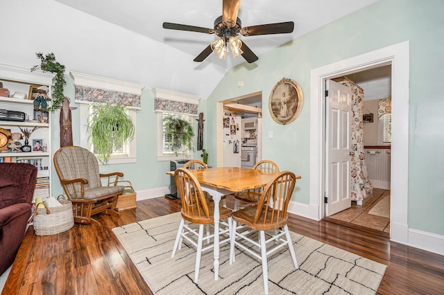 dining area with a ceiling fan, baseboards, wood finished floors, and lofted ceiling