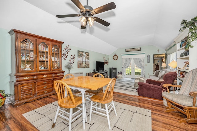 dining area with a ceiling fan, lofted ceiling, and wood finished floors